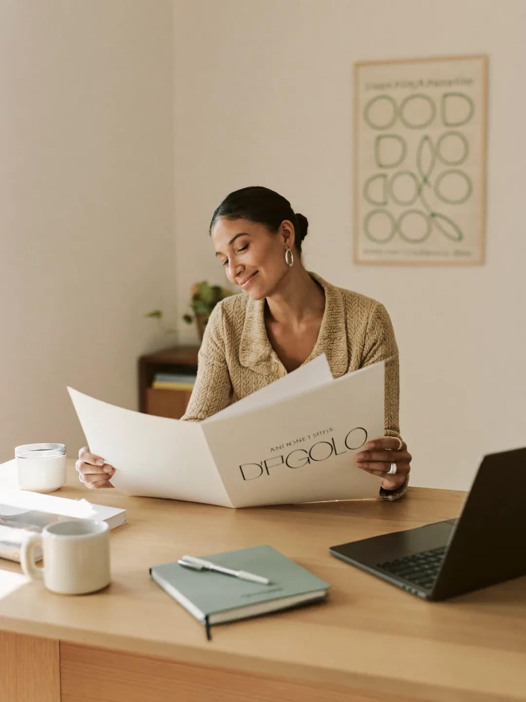 Freelance designer reviewing printed brand work at her desk